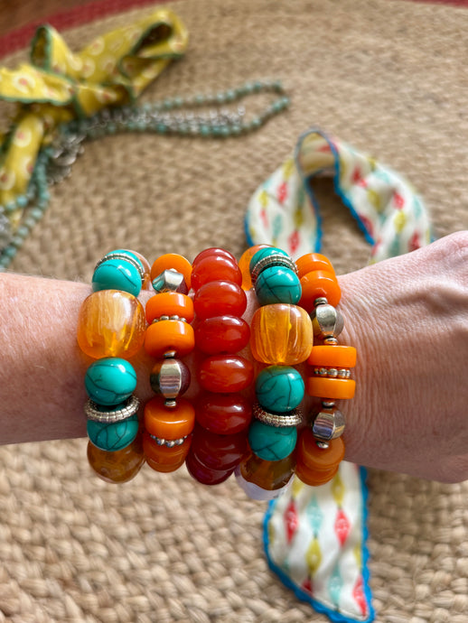 Multicolored beaded bracelets on a wrist with a textured surface background