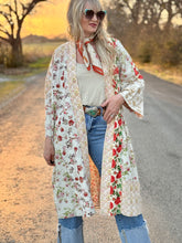 Woman in a floral kimono standing on a road with a sunset background
