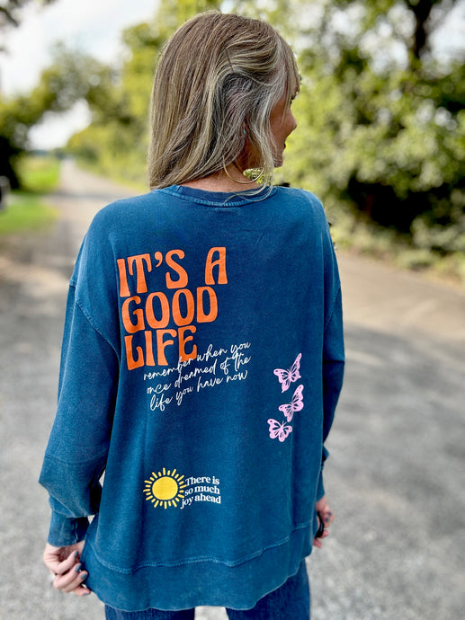 Person wearing a blue sweatshirt with text and butterfly designs outdoors