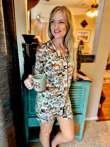 Woman in a patterned pajama set holding a mug in a home setting