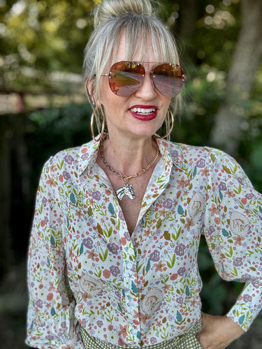 Woman wearing a floral shirt and sunglasses outdoors