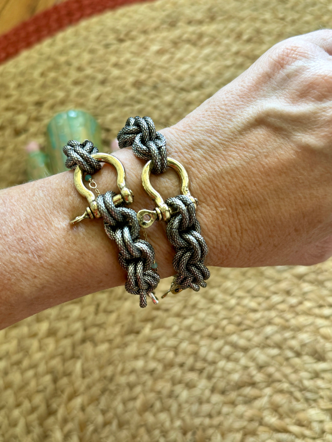 Close-up of a wrist wearing multiple bracelets on a textured surface