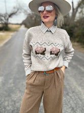 Woman wearing a patterned sweater and hat on a road