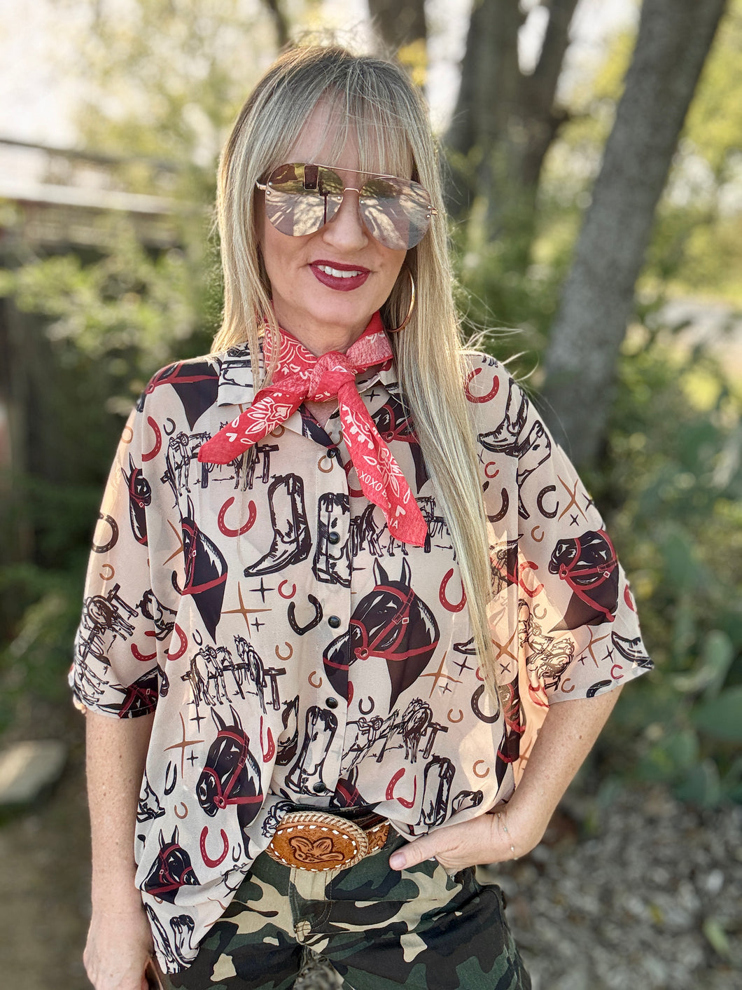 Woman wearing a patterned shirt with cowboy design outdoors