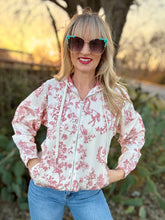 Woman wearing a floral jacket and sunglasses outdoors