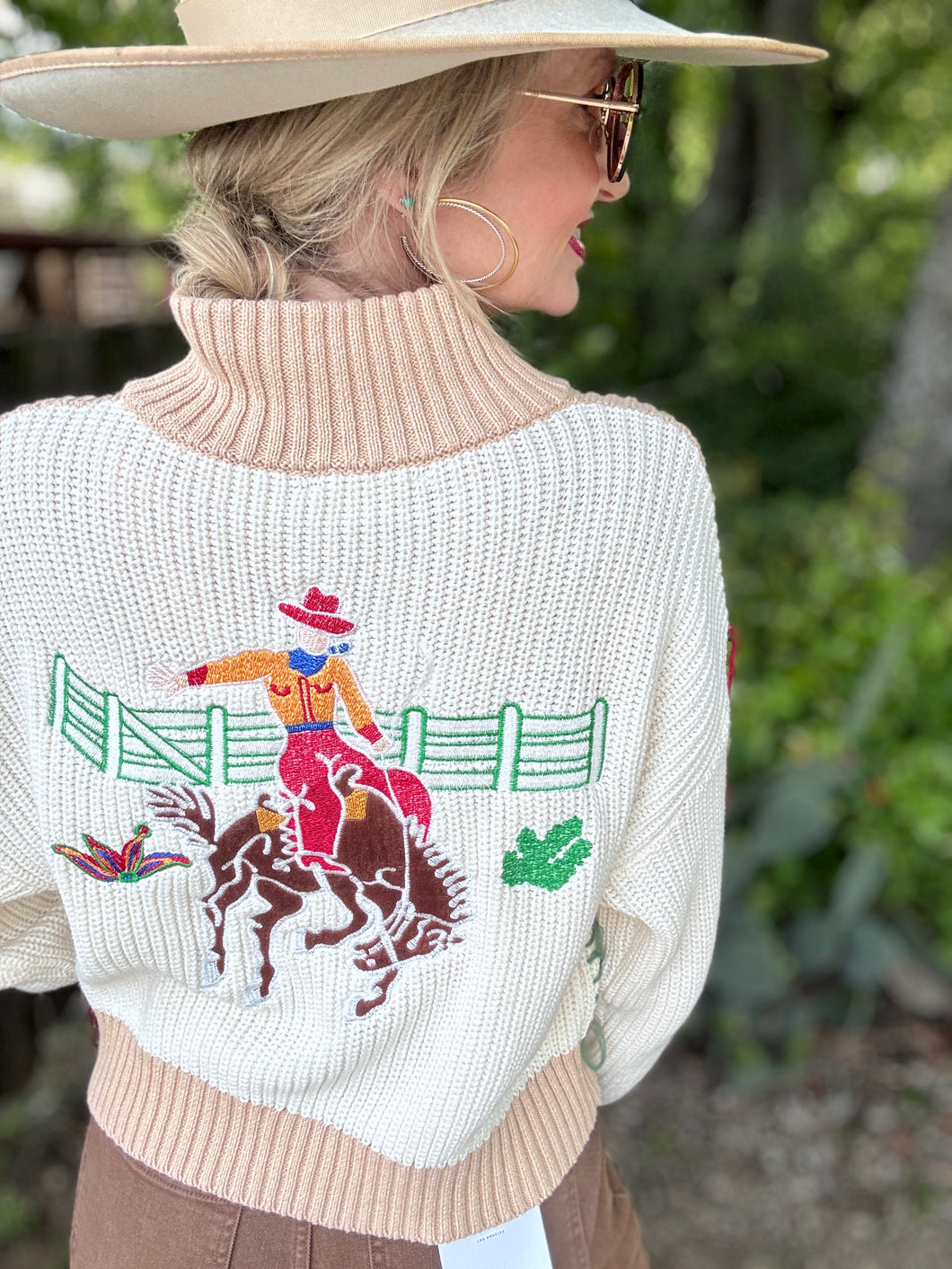 Person wearing a sweater with a rodeo design outdoors
