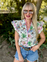 Woman wearing a floral blouse and sunglasses outdoors