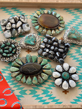 Collection of various stone and metal buckles on a patterned surface