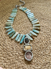 Necklace with turquoise and silver design on a woven surface