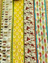 Collection of fabric scarves with various patterns including animals and geometric shapes.