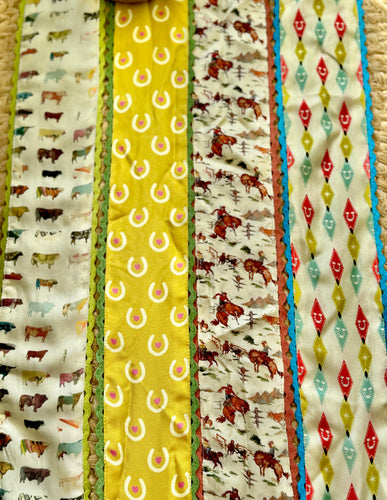 Collection of fabric scarves with various patterns including animals and geometric shapes.