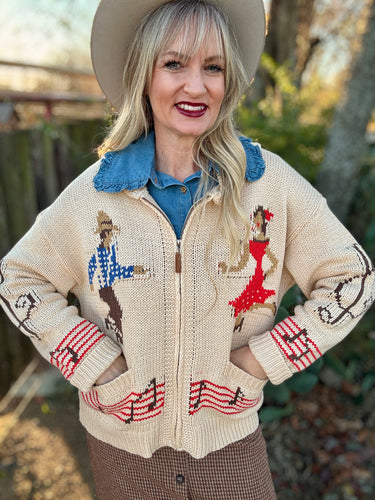 Woman wearing a patterned sweater with a blue shirt underneath, standing outdoors.