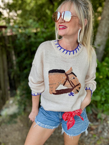 Woman wearing a sweater with a horse design outdoors