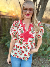 Woman wearing a red and white floral blouse outdoors