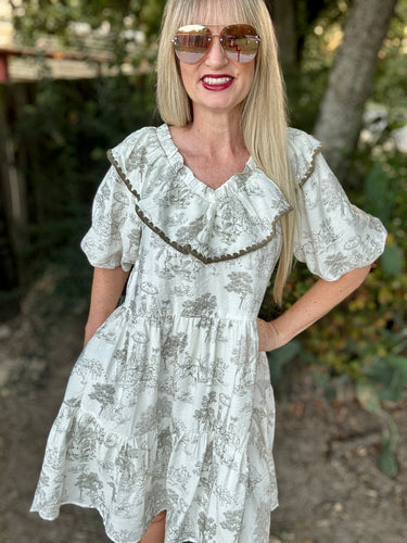 Woman wearing a white floral dress with ruffled details outdoors.
