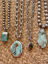 Set of necklaces with stone pendants on a woven surface